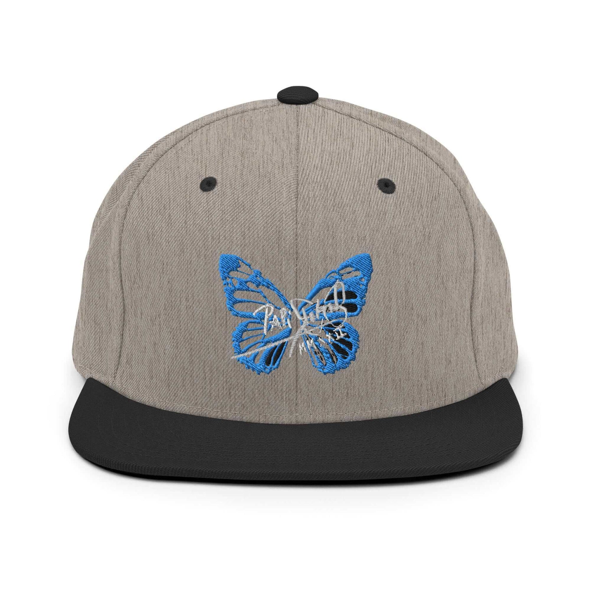 PapiJohn® The Blue Butterfly Snapback Archive in black heather textured weave front view tracing the blue butterfly stitch work over the curated grain matrix | Sala 1 Wearable Art Fashion