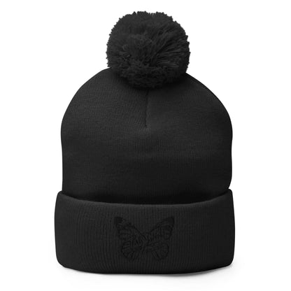 PapiJohn® The Butterfly Signature Pom-Pom Beanie in solid black front view displaying the premium black thread butterfly design embroidered in high density by $arah Free 💎 | Sala 1 Wearable Art Fashion