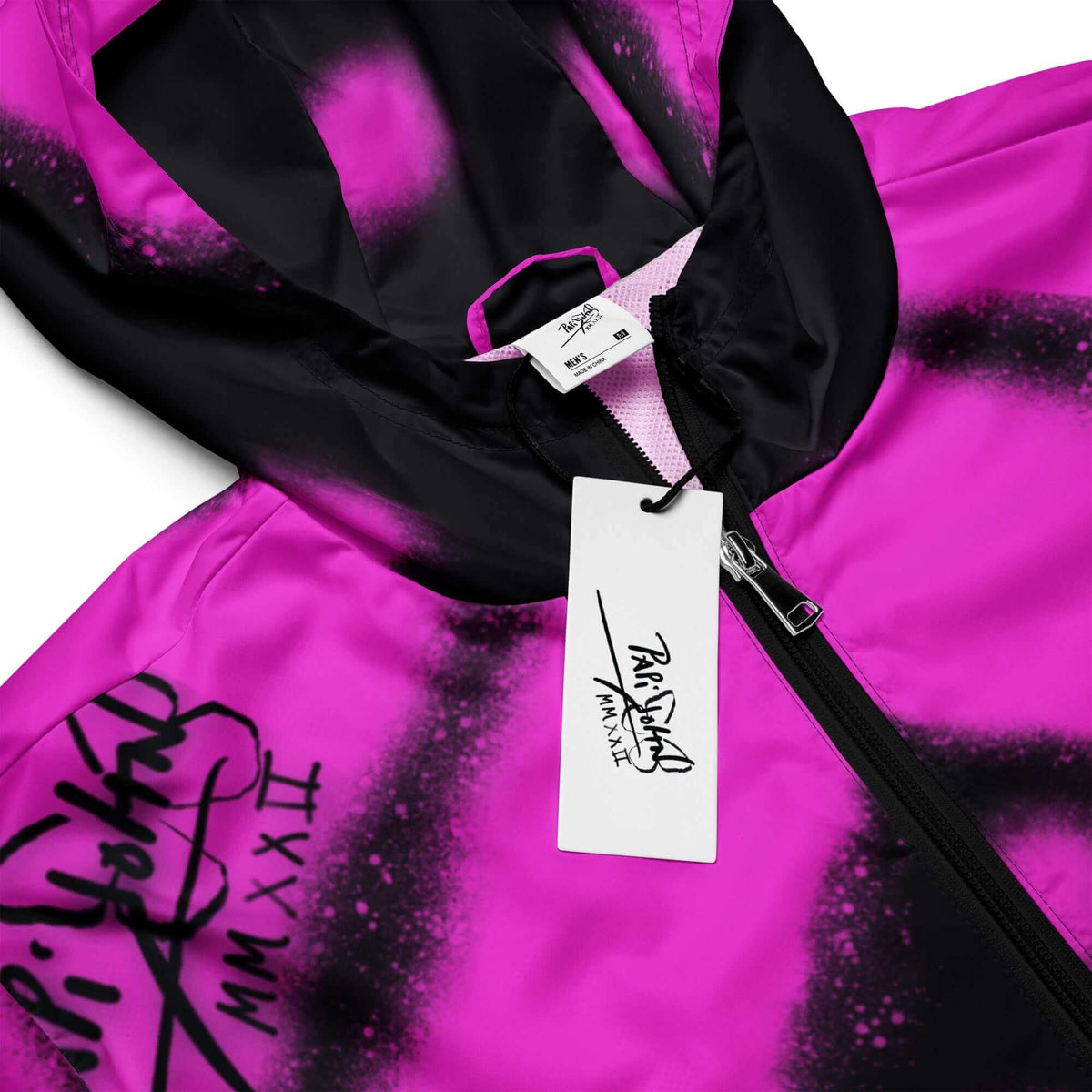 Close-up detail view showing the custom PapiJohn® brand tag and high-definition fuchsia pink action painting splatter texture on the SALA 3 | Attitude Topos Graff Windbreaker by $arah Free 💎. Honest luxury craftsmanship curated in Cadifornia.
