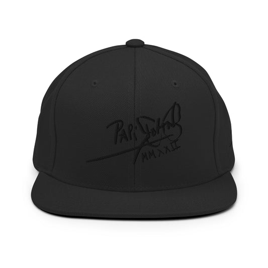 PapiJohn® The Black Signature Classic Snapback premium headwear front view showcasing the high-density black-on-black embroidered script signature on a structured black wool blend high-crown profile by $arah Free 💎 | Artist-Driven Streetwear