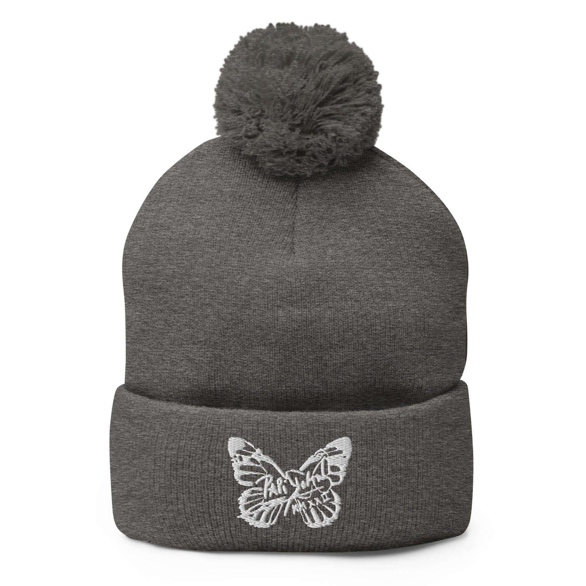 PapiJohn® The White Butterfly Pom-Pom Beanie in dark heather grey canvas front view tracking the beautiful definition of the central white butterfly thread design by $arah Free 💎 | High-End Subcultural Archive