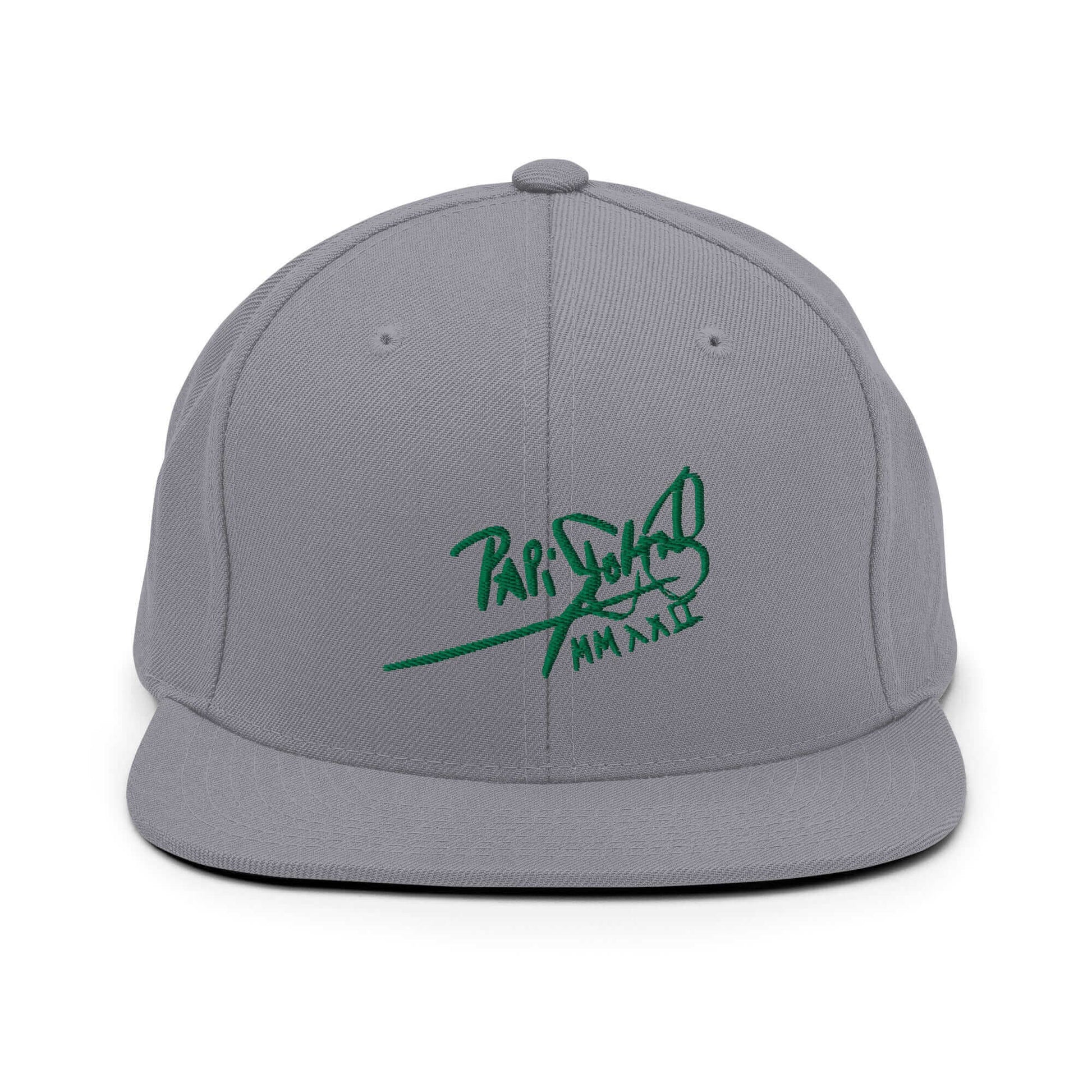PapiJohn® The Green Signature Classic Snapback in metallic silver canvas front view focusing on the clean definitions of the volumetric green embroidered script | Sala 1 Wearable Art Fashion